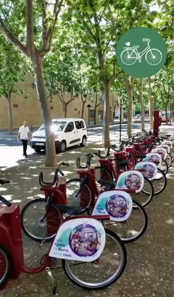 Foto de bicicletas municipales en Logroño con la campaña dibujada por Eva Cortés "Cuida la tierra, es tu casa"
