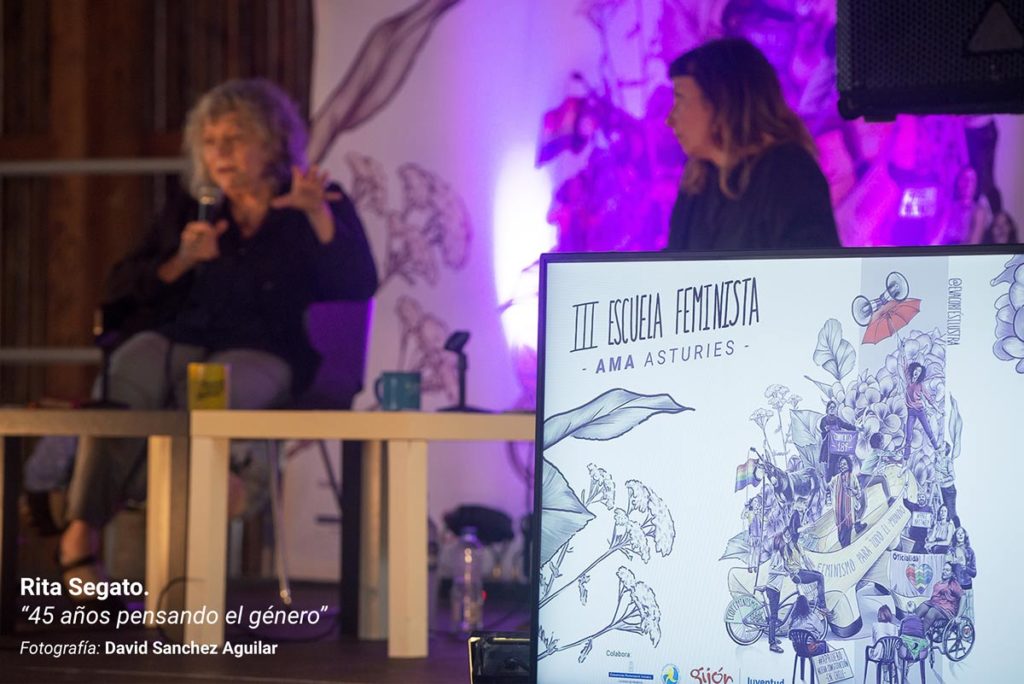 Rita Segato, durante su ponencia en la III Escuela Feminista AMA Asturies, con la gráfica de fondo de Eva Cortés Ilustra