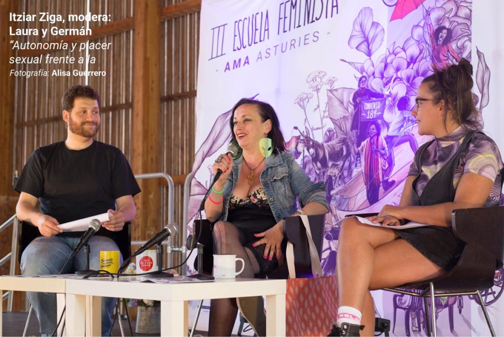 Itziar Ziga, durante su ponencia en la III Escuela Feminista AMA Asturies, con la gráfica de fondo de Eva Cortés Ilustra