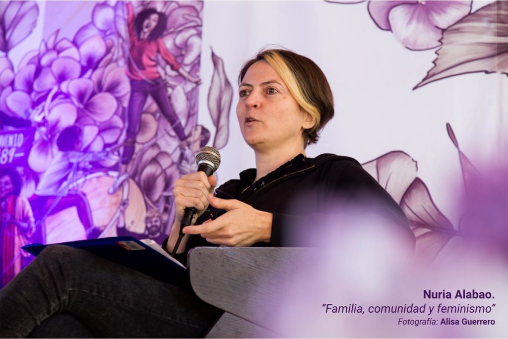 Nuria Alabao, durante su ponencia en la III Escuela Feminista AMA Asturies, con la gráfica de fondo de Eva Cortés Ilustra