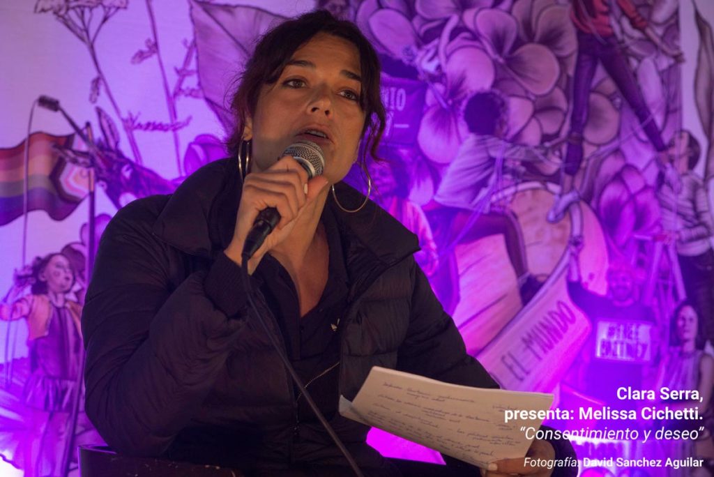 Clara Serra, durante su ponencia en la III Escuela Feminista AMA Asturies, con la gráfica de fondo de Eva Cortés Ilustra