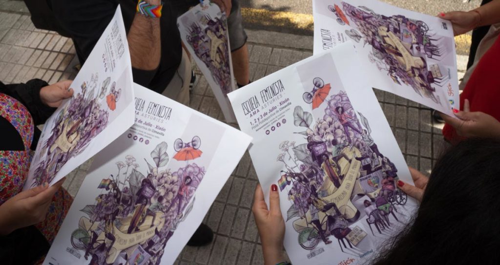 Miembros de AMA Asturies (Asamblea Moza d´Asturies) sujetando los carteles y observandolos.