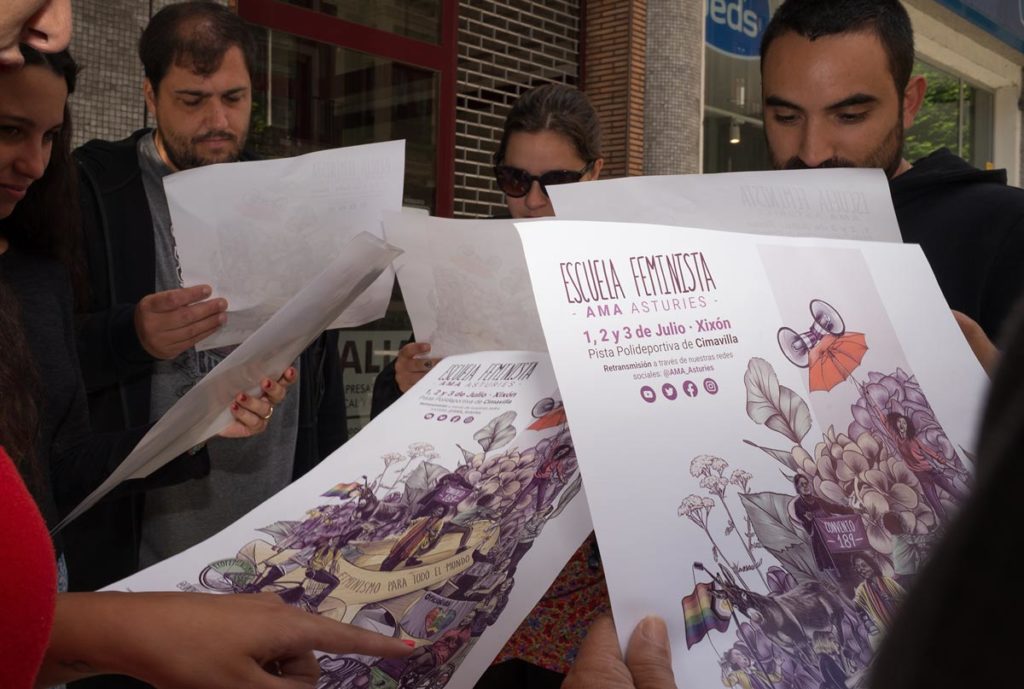 Miembros de AMA Asturies (Asamblea Moza d´Asturies) sujetando los carteles y observandolos.